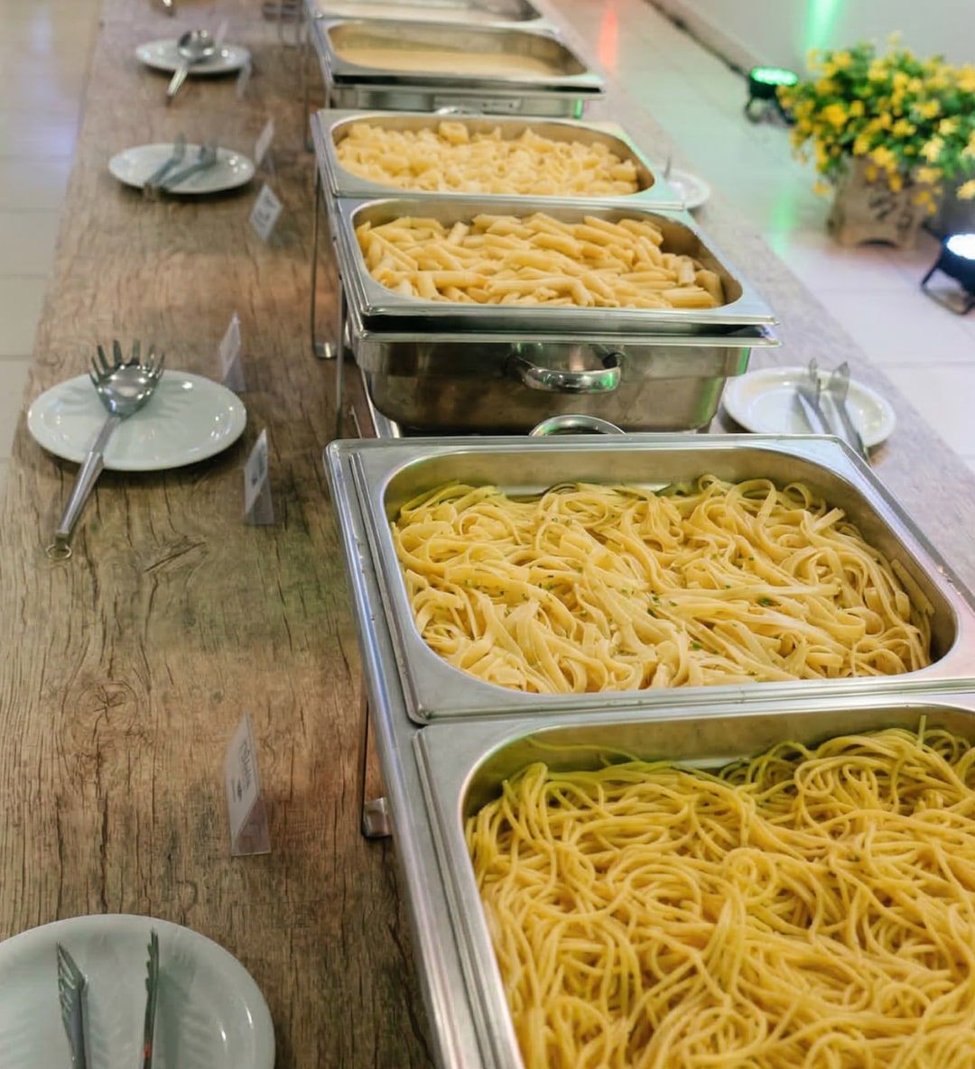 Buffet de almoço com massas em réchauds para evento de empresa