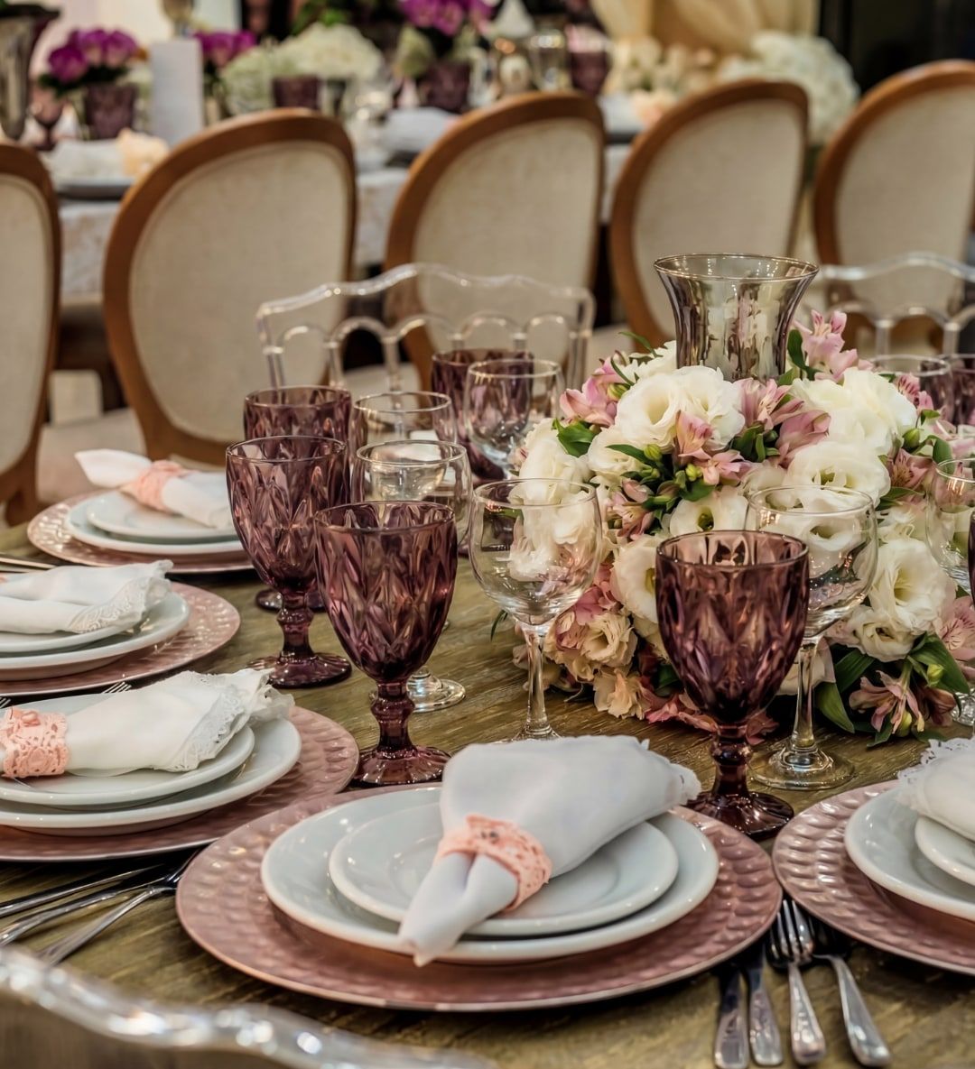 Mesa posta com louça, taças e arranjo de flores em casamento no Espaço Belladata
