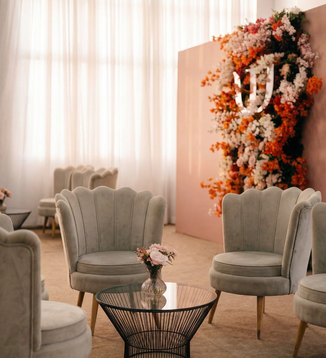Lounge com poltronas cinza e arranjo de flores em formatura